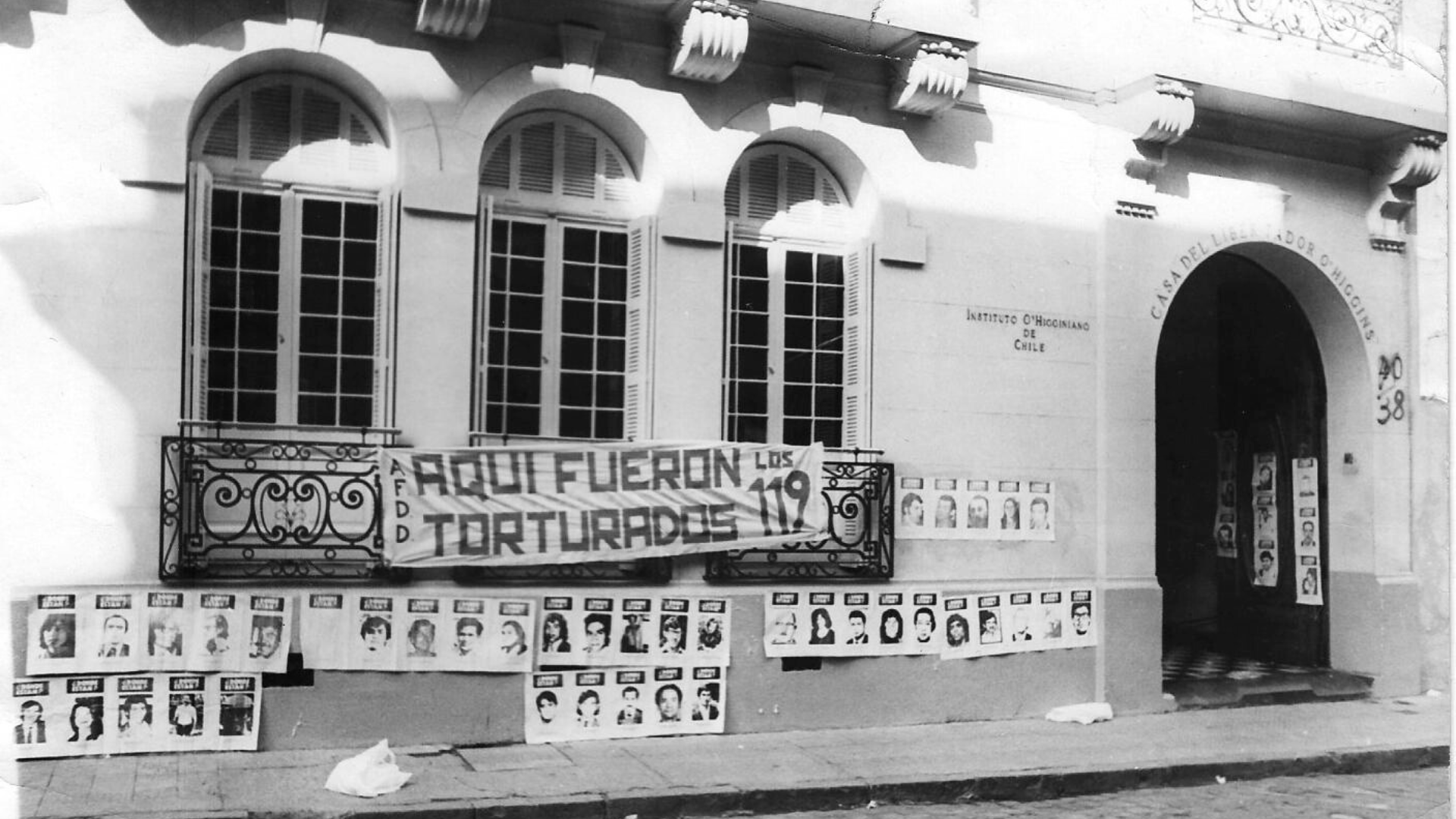 1980 yılında çekilen bu fotoğrafta o dönem O’Higgins Askerî Araştırma Enstitüsü olarak kullanılan binaya “Aquí fueron torturados los 119 / 119 kişi burada işkence gördü” yazılı bir pankart asılmış.