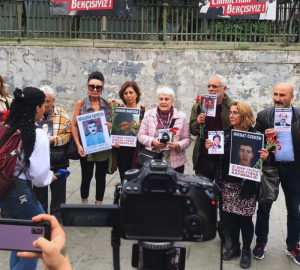 Cumartesi Anneleri'ni temsilen 10 kişi Galatasaray Meydanı'nda karanfil ve kayıp yakınının fotoğrafını tutuyor.
