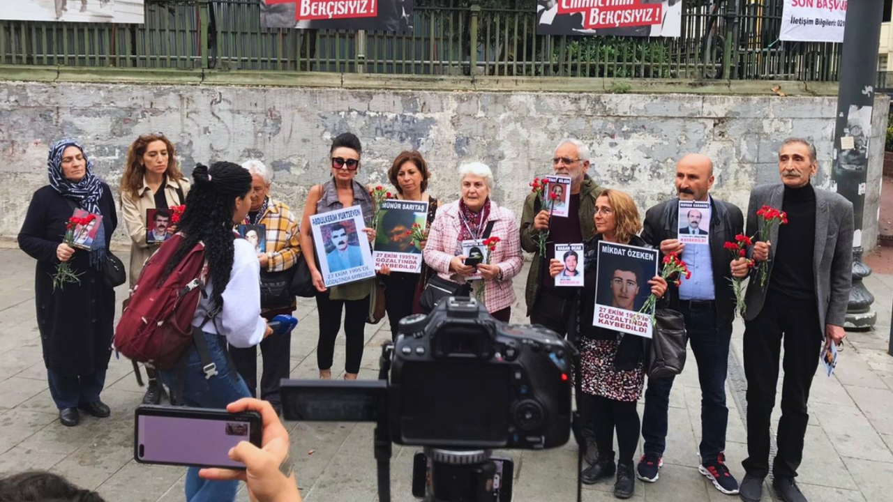 Cumartesi Anneleri'ni temsilen 10 kişi Galatasaray Meydanı'nda karanfil ve kayıp yakınının fotoğrafını tutuyor.