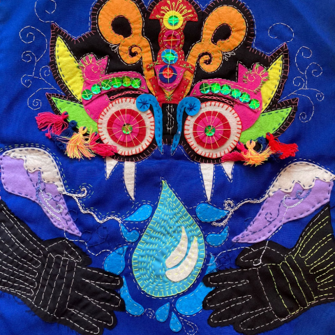 Erika’nın seçtiği ilk arpillera, mavi fon üzerine ejderhaya benzer pullu bir şeytan figürünü gösteriyor.